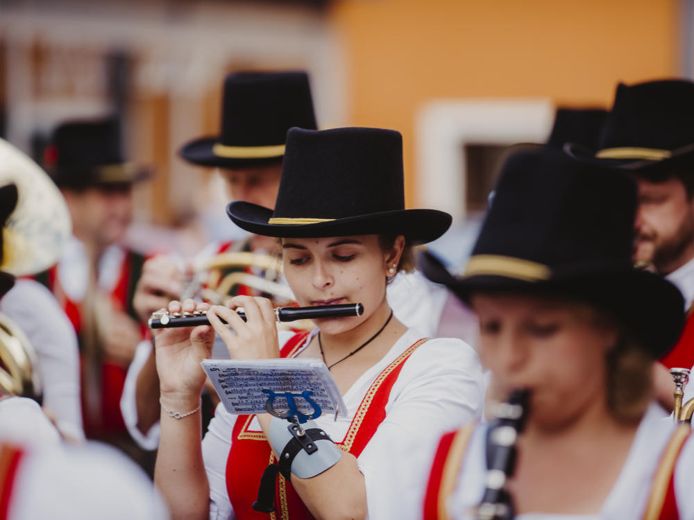 Fluitist en orkest op het stadsfeest in Mittersill, feestelijke sfeer tegen de achtergrond van de stad.