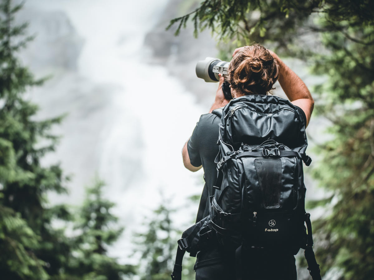 Photographer in front of the Krimml Waterfalls, a popular excursion destination near Mittersill, surrounded by the impressive natural scenery of the Alps.