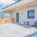 Modern, licht terras met stenen vloer en gezellig zitje, zonnig en uitnodigend in de vakantiewoning Hoferlitzlhubgut in Mittersill. thumbnail