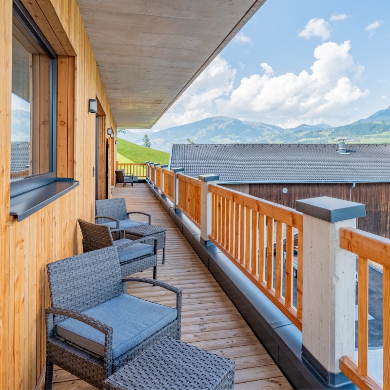 Sunny balcony with seating and view towards Resterhöhe in the Hoferlitzlhubgut vacation apartment in Mittersill.
