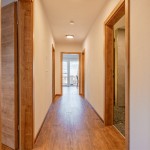 Lichte, moderne hal met houten vloer en houten deuren in de vakantiewoning Hoferlitzlhubgut in Mittersill. thumbnail