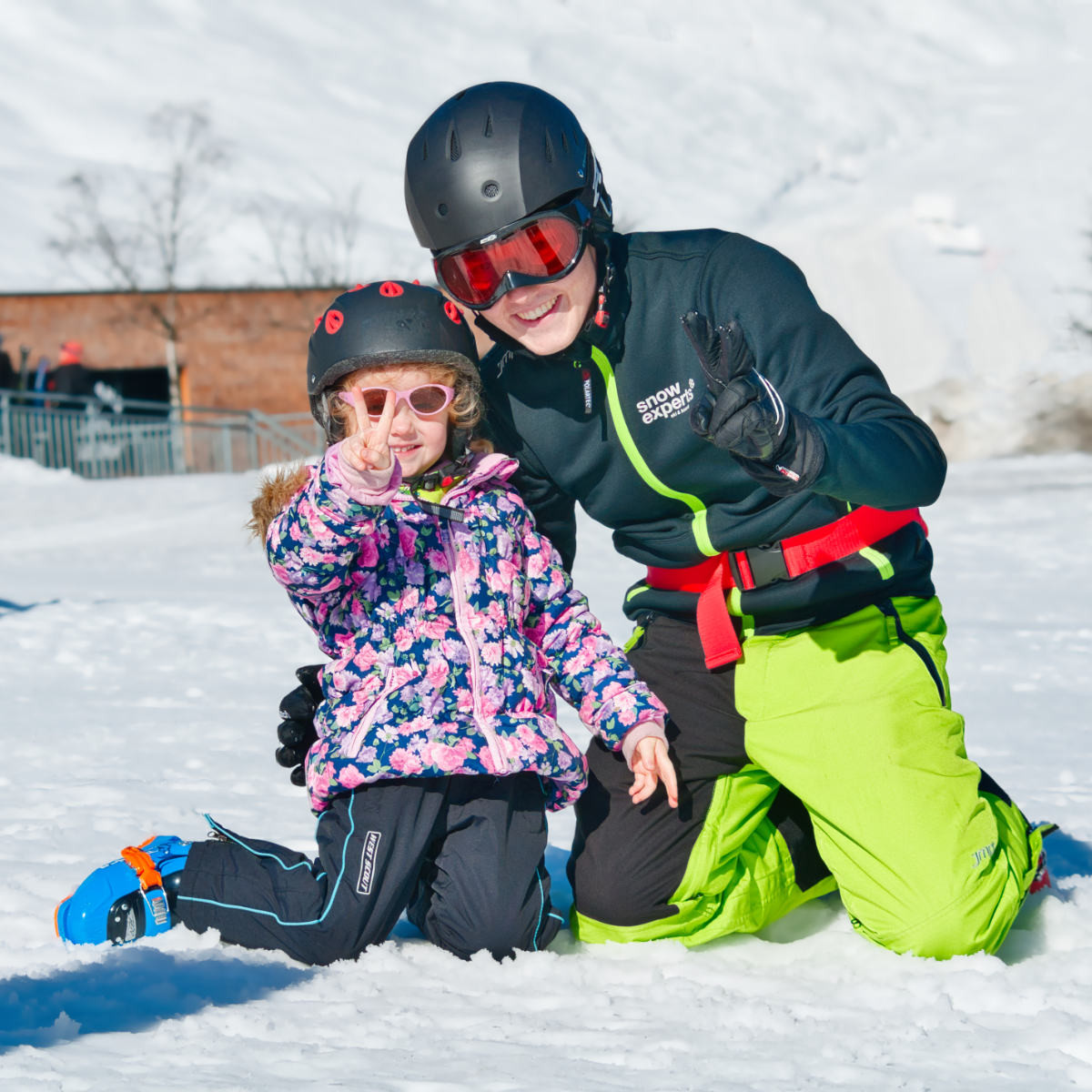 In the KitzSki ski area, ski instructors and ski students laugh together in the snow and show the joy and loving interaction with children.
